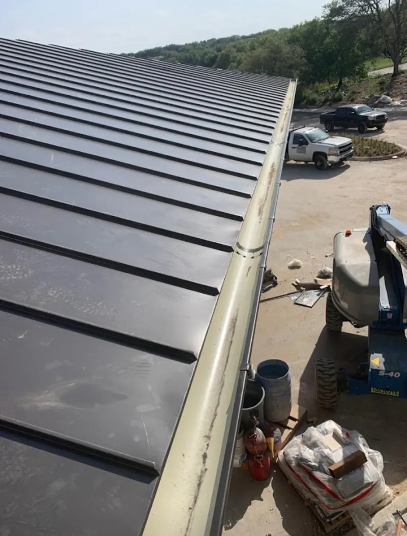 Standing seam panel and gutter detail on a metal roofing jobsite in Great Falls